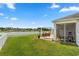 Private backyard featuring a white picket fence, lush green lawn, patio, and picturesque lake views at 568 Mossbank Loop, Longs, SC 29568