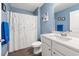 Bathroom with blue walls, tub and shower, vanity with mirror, and white fixtures at 568 Mossbank Loop, Longs, SC 29568