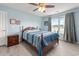 Comfortable bedroom with a wooden bed frame, ceiling fan, and bright natural light at 568 Mossbank Loop, Longs, SC 29568