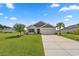 Well-maintained single-story home with lush green lawn, mature trees, and attached two-car garage at 568 Mossbank Loop, Longs, SC 29568