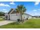Home with a manicured lawn, complemented by a palm tree and colorful flower beds at 568 Mossbank Loop, Longs, SC 29568