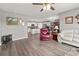 Open-concept living room flows to kitchen and dining, featuring cozy seating and wood flooring at 568 Mossbank Loop, Longs, SC 29568