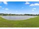 View of the community pond, adjacent houses, and blue sky with clouds at 568 Mossbank Loop, Longs, SC 29568
