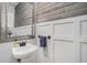 Charming powder room boasts white wainscoting, wood paneling, decorative mirror, and a pedestal sink for a timeless appeal at 58 Fathom Ln., Murrells Inlet, SC 29576