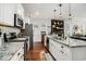 Open kitchen with stainless appliances, granite countertops, island with sink, and hardwood floors that flow into the living area at 58 Fathom Ln., Murrells Inlet, SC 29576