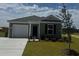 Charming single-story home with green siding, an attached garage and manicured front lawn at 597 Strawberry Field Way, Galivants Ferry, SC 29544