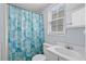 Bright bathroom with a blue patterned shower curtain, white fixtures, and a window letting in natural light at 6001-1623 S Kings Hwy., Myrtle Beach, SC 29575
