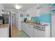 Compact kitchen featuring white cabinets, a turquoise backsplash, and essential appliances at 6001-1623 S Kings Hwy., Myrtle Beach, SC 29575