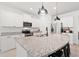 Bright kitchen features a granite island with sink and black pendant lighting, stainless appliances, and white cabinets at 625 Heritage Downs Dr., Conway, SC 29526