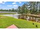 Scenic view of pond featuring a fountain, lush green lawn, and pair of ducks at 701 Wilshire Ln. # 0, Murrells Inlet, SC 29576