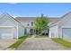 Home's rear exterior with a shared driveway and attached garages, showcasing a well-kept lawn at 816 Barn Owl Ct. # 816, Myrtle Beach, SC 29579