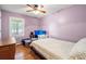 Relaxing bedroom with light purple walls, wood floors, and a double bed, complemented by a window and vintage furniture at 8506 Old Nichols Hwy., Nichols, SC 29581