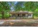 Charming home with a covered front porch and rocking chairs, set amidst mature trees at 8506 Old Nichols Hwy., Nichols, SC 29581
