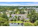 Drone shot displaying the pond, trees, and townhomes in this community with ample parking at 97 Shadow Moss Pl. # 97, North Myrtle Beach, SC 29582