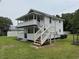 Two-story white home with a covered porch, deck, and two staircases leading to the ground at 1022 Holt Rd., Conway, SC 29526