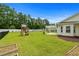 Expansive backyard features a pergola-covered patio, playset, above ground pool, and ample space for outdoor activities at 104 Browns Hollow Ct., Loris, SC 29569