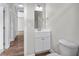 Bright bathroom featuring a white vanity with a modern sink, mirror, and wood look flooring at 104 Browns Hollow Ct., Loris, SC 29569