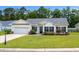 Charming single-story home with manicured lawn, an attached garage, and a beautifully landscaped front yard at 104 Browns Hollow Ct., Loris, SC 29569