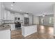 Beautiful kitchen features white cabinets, granite countertops and stainless steel appliances, with an island and an open view to the living room at 104 Browns Hollow Ct., Loris, SC 29569