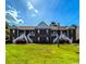Charming townhome featuring a well-manicured lawn and appealing architectural details, including white staircases and a brown facade at 1101 Peace Pipe Pl. # 104, Myrtle Beach, SC 29579