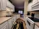 Bright kitchen with white cabinets, a double sink, and views to a dining area at 1101 Peace Pipe Pl. # 104, Myrtle Beach, SC 29579