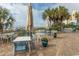 Outdoor patio and seating area with dining tables and chairs near the beach and palm trees at 1105 S Ocean Blvd. # 932, Myrtle Beach, SC 29577