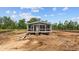 New construction home showing the front elevation with an inviting front porch and visible construction site surroundings at 1321 Rabbit Ln., Conway, SC 29526