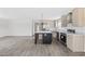 Bright kitchen with island, stainless appliances, light wood cabinets, and view to living room at 1321 Rabbit Ln., Conway, SC 29526