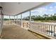 Relaxing outdoor porch with wooden floors, white railings, and posts showcasing scenic views of the surrounding property at 1321 Rabbit Ln., Conway, SC 29526