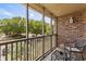 Screened balcony with chairs and table, overlooking trees and a parking lot, providing relaxing outdoor space at 1356 Glenns Bay Rd. # A202, Surfside Beach, SC 29575