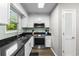 Bright kitchen with white cabinets, black granite counters, stainless steel appliances, and hardwood floors at 1356 Glenns Bay Rd. # A202, Surfside Beach, SC 29575