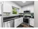 Bright kitchen with white cabinets, black granite counters, stainless steel appliances, and stylish backsplash at 1356 Glenns Bay Rd. # A202, Surfside Beach, SC 29575