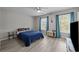 Bright bedroom featuring large windows, with gray hardwood floors and blue curtains at 1409 Highway 15 # 4, Myrtle Beach, SC 29577