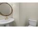 This powder room features a white pedestal sink, toilet, and an ornate oval mirror at 141 Cayman Loop, Pawleys Island, SC 29585