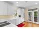 Well-lit kitchen with white cabinetry, appliances, and hardwood floors with an open doorway to a porch at 141 Cayman Loop, Pawleys Island, SC 29585