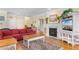 Cozy living space with a red sectional, fireplace, and hardwood floors throughout at 141 Cayman Loop, Pawleys Island, SC 29585