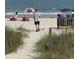 A serene beach scene with an adult and a dog walking near the ocean at 1432 Seahouse Ct., Surfside Beach, SC 29575