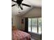 Well-lit bedroom with a high ceiling, fan, and large windows showcasing serene outdoor views at 1432 Seahouse Ct., Surfside Beach, SC 29575