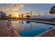 Outdoor swimming pool reflecting sunset, palm trees, and nearby buildings at 1501 Ocean Blvd. S # 242, Myrtle Beach, SC 29577