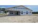 Backyard view showcasing a home under construction with a patio and large windows at 1531 Breakwater Dr., Little River, SC 29566
