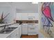 Clean, galley kitchen with white cabinets, tile backsplash, stainless steel sink, and modern appliances at 1551 Spinnaker Dr. # 5312, North Myrtle Beach, SC 29582