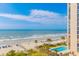 Gorgeous ocean view from the balcony with sandy beach, blue umbrellas, and palm trees at 161 Sea Watch Dr. # 601, Myrtle Beach, SC 29572