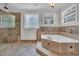 Luxurious bathroom with travertine tile, a soaking tub, and a separate glass-enclosed shower at 1619 Eastover Ln., North Myrtle Beach, SC 29582