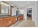 Bathroom with dual sinks, black marble countertops, wood cabinets, and travertine floors at 1619 Eastover Ln., North Myrtle Beach, SC 29582
