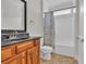 Well lit bathroom featuring a shower, toilet and a vanity with a dark marble countertop at 1619 Eastover Ln., North Myrtle Beach, SC 29582