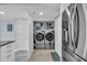 Laundry closet with washer and dryer, neatly organized with storage shelves at 1625 S Ocean Blvd. # 211, North Myrtle Beach, SC 29582