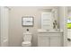 Inviting bathroom featuring white fixtures, a large mirror, and a painting creating a modern, clean space at 1744 Hunting Harris Ct # 10, Ocean Isle Beach, NC 28469
