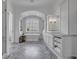 Bright bathroom with soaking tub, marble floor, arched window and and vanities at 191 Grackle Ln., Pawleys Island, SC 29585