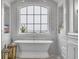 Bathroom with soaking tub under large window with ocean view and decorative sconces at 191 Grackle Ln., Pawleys Island, SC 29585
