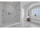 Elegant bathroom featuring a glass shower, soaking tub, and marble tiling at 191 Grackle Ln., Pawleys Island, SC 29585